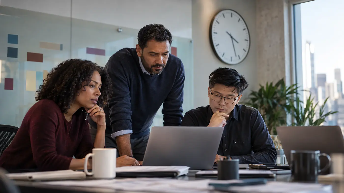 Product and revenue operations colleagues reviewing a timed experiment stop beside a wall clock.