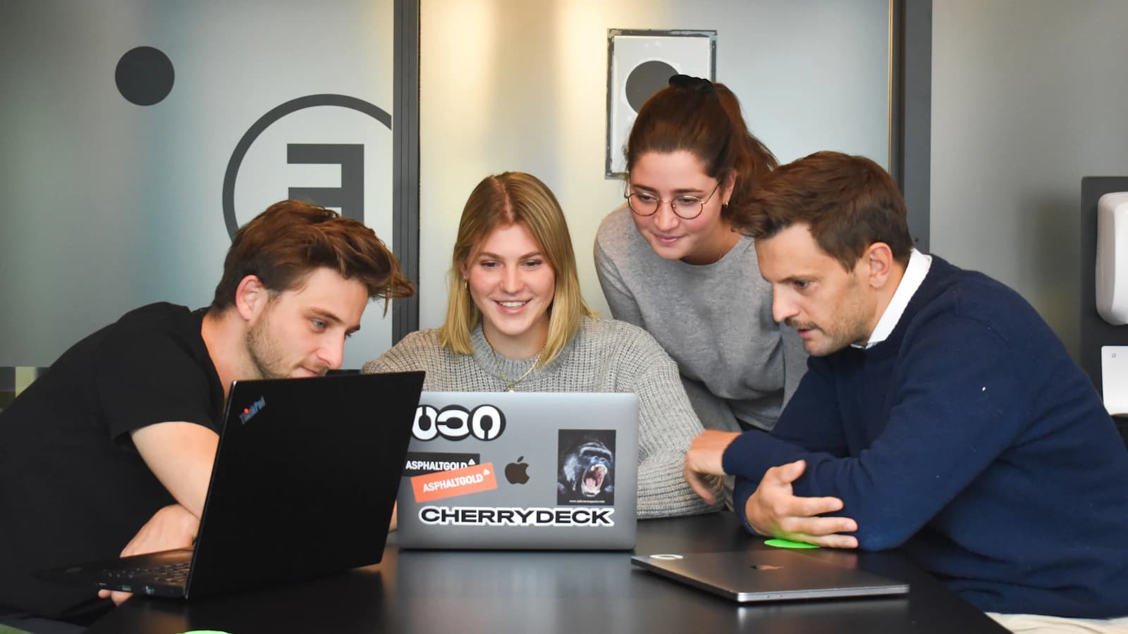 Revenue operations team reviewing an AI-assisted campaign workflow with the official UserGems logo overlay