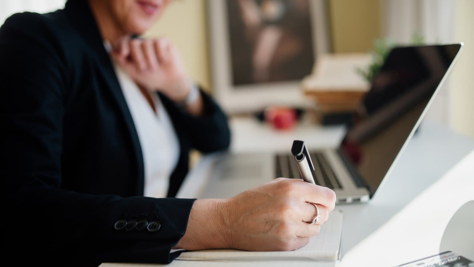 RevOps operator taking renewal tracking notes beside a laptop before replacing spreadsheet follow-up with CRM-owned tasks