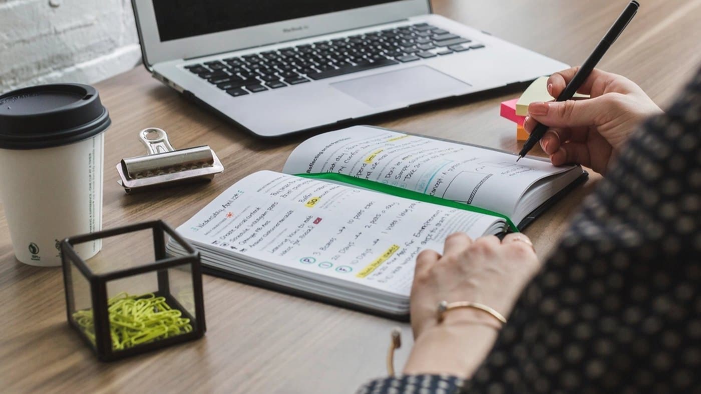 Revenue operations professional checking field cleanup notes and source records during a CRM data quality session